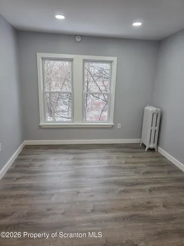 a view of room with window and wooden floor