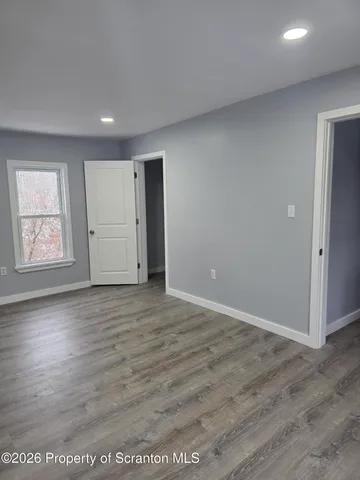 an empty room with wooden floor and window