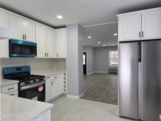 a kitchen with stainless steel appliances a refrigerator a stove top oven a sink and cabinets