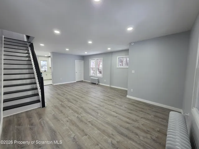 a view of empty room with wooden floor