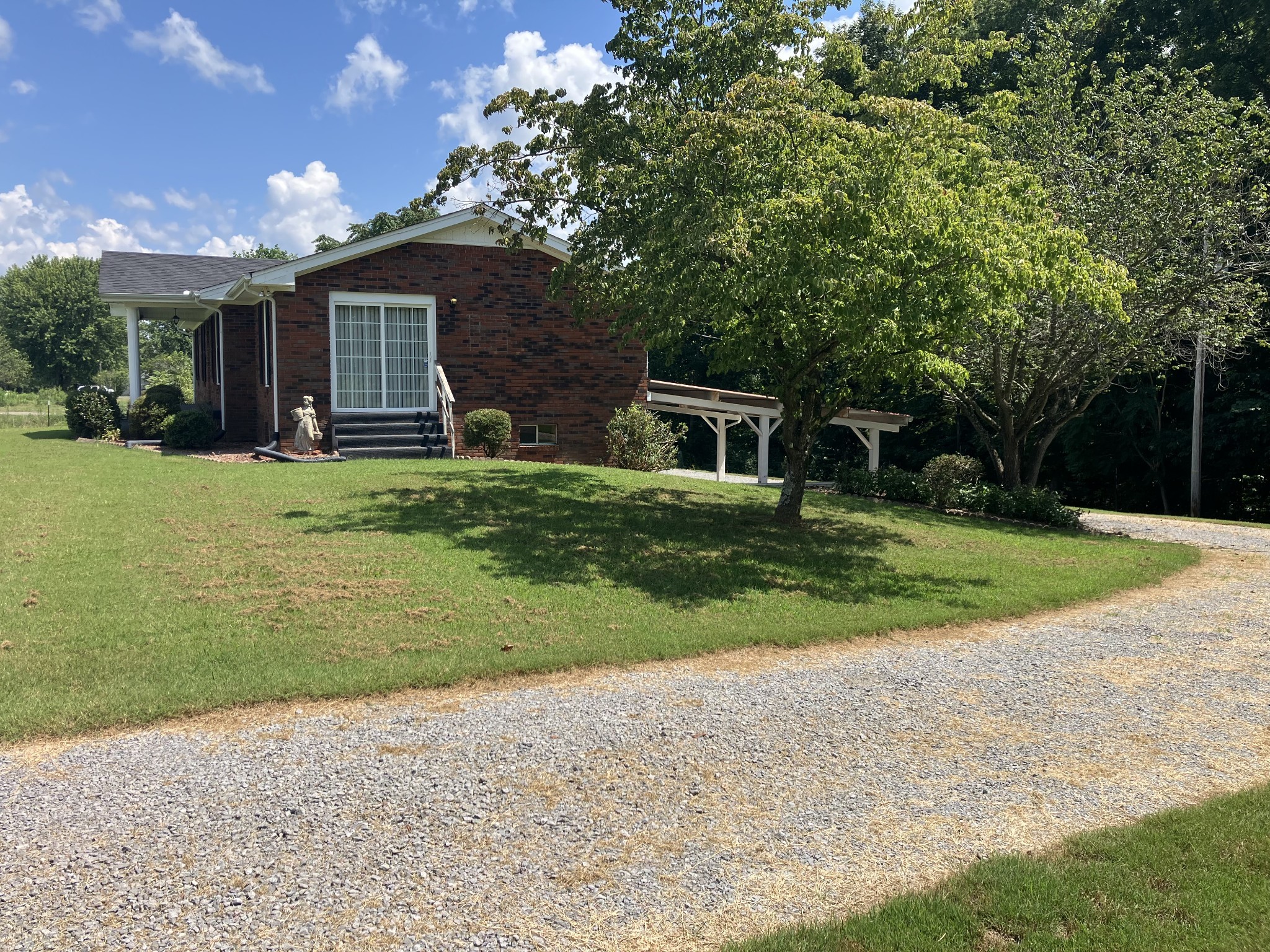 5279 Oak Grove Road Red Boiling Springs, TN 37150 - Photo 3 of 23 a backyard of a house with plants and large tree
