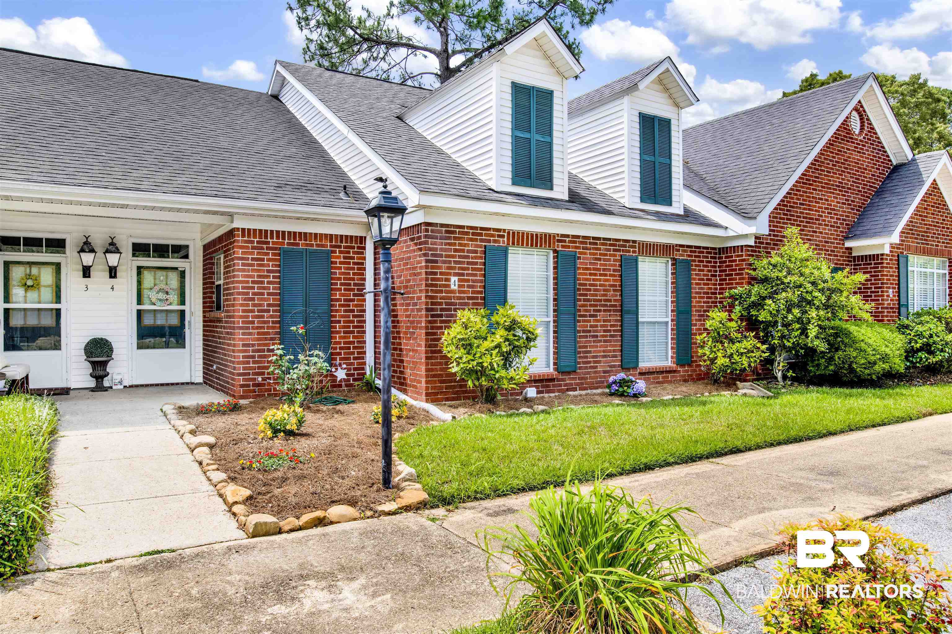 1258 Sutton Court, Unit 4 Mobile, AL 36609 - Photo 1 of 19 Cape cod house featuring roof with shingles, a front lawn, and brick siding