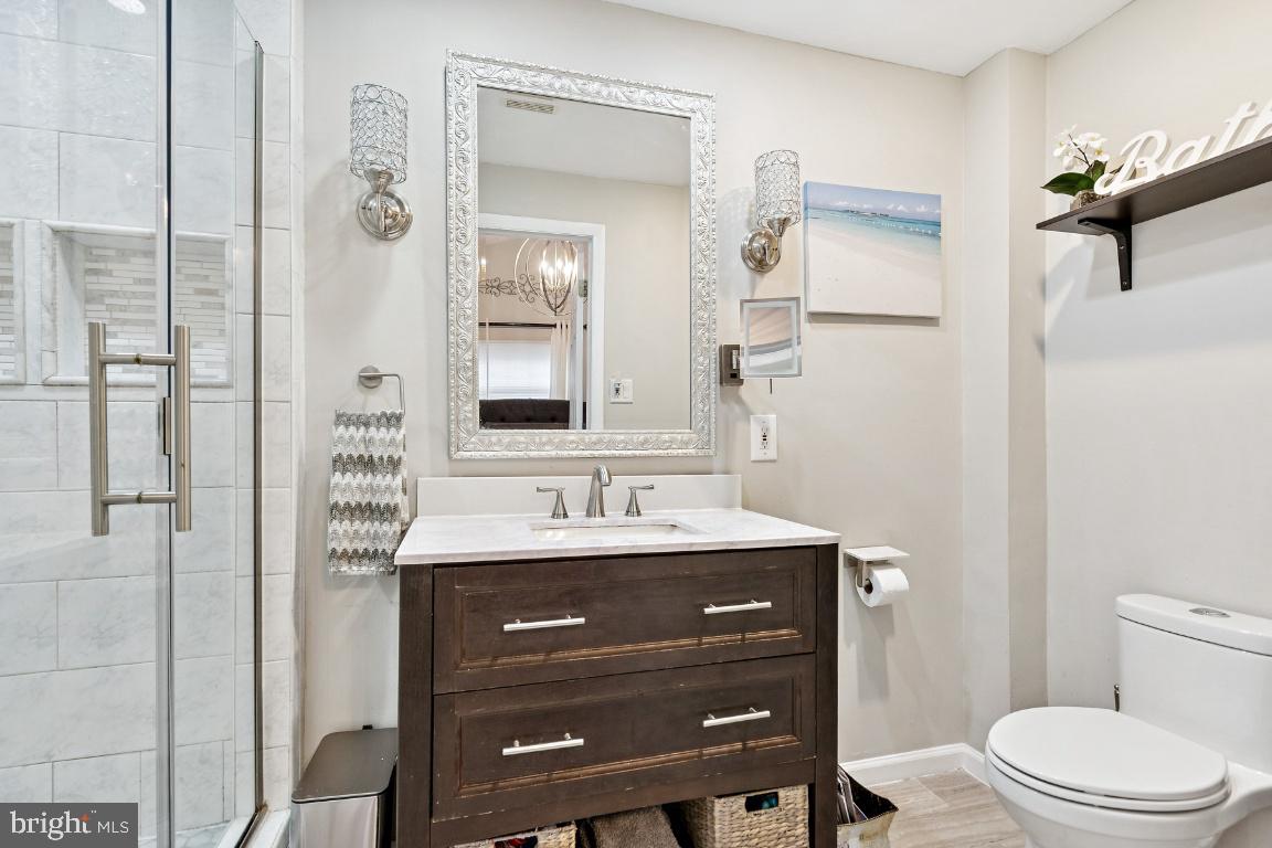 13 Belmont Road Bellmawr, NJ 08031 - Photo 11 of 32 a bathroom with a sink a toilet a mirror and shower