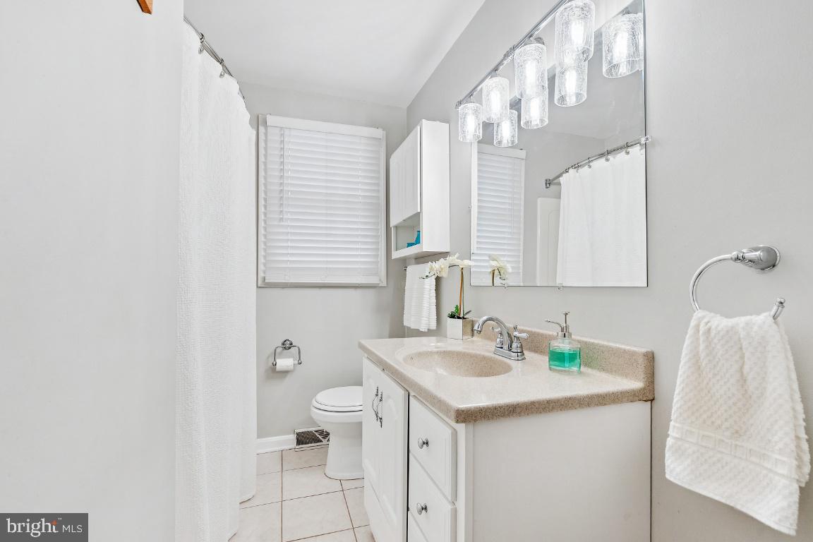 13 Belmont Road Bellmawr, NJ 08031 - Photo 12 of 32 a bathroom with a sink a toilet and a mirror