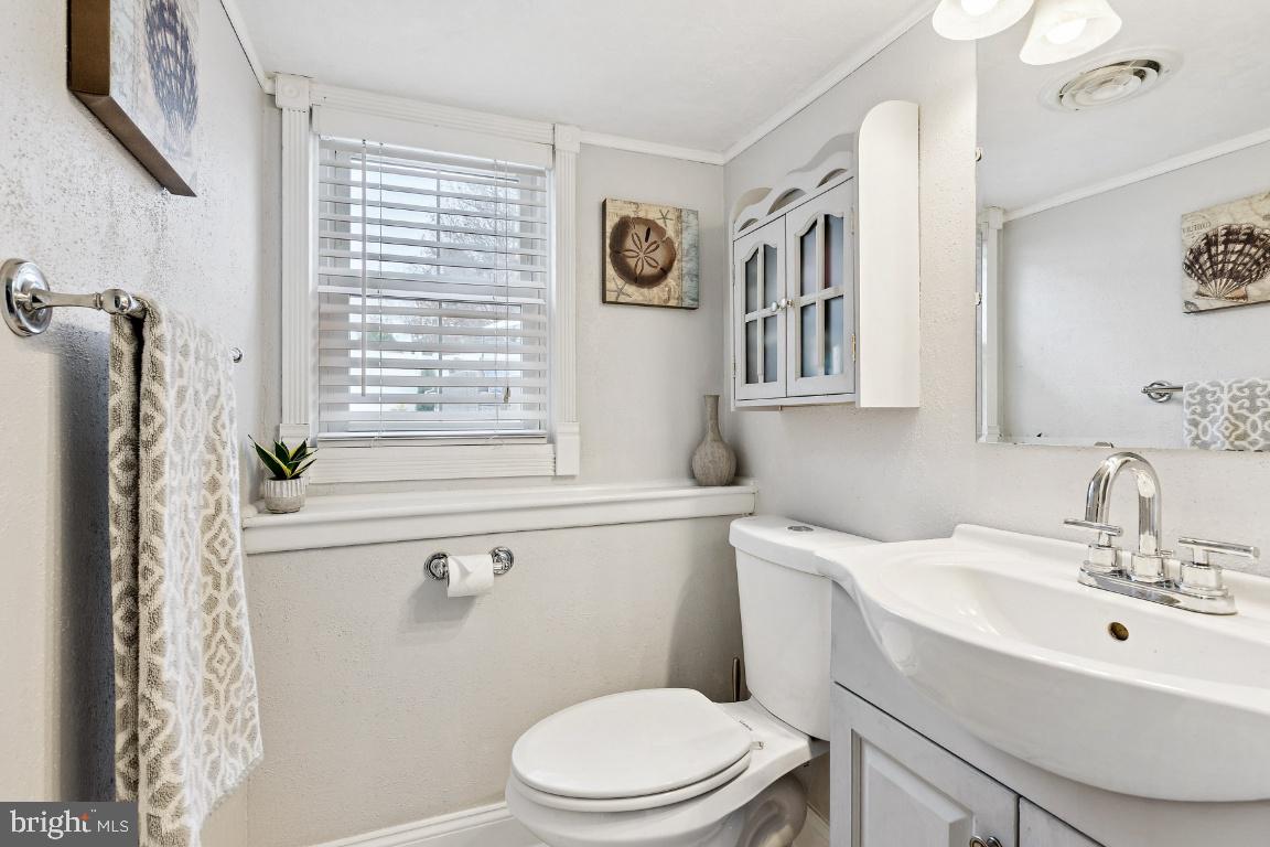 13 Belmont Road Bellmawr, NJ 08031 - Photo 18 of 32 a bathroom with a sink a toilet and a mirror