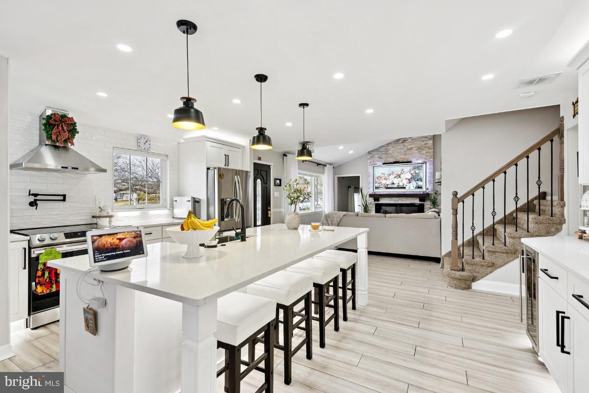 13 Belmont Road Bellmawr, NJ 08031 - Photo 2 of 32 a open kitchen with stainless steel appliances kitchen island granite countertop a stove a sink a refrigerator and a dining table with wooden floor