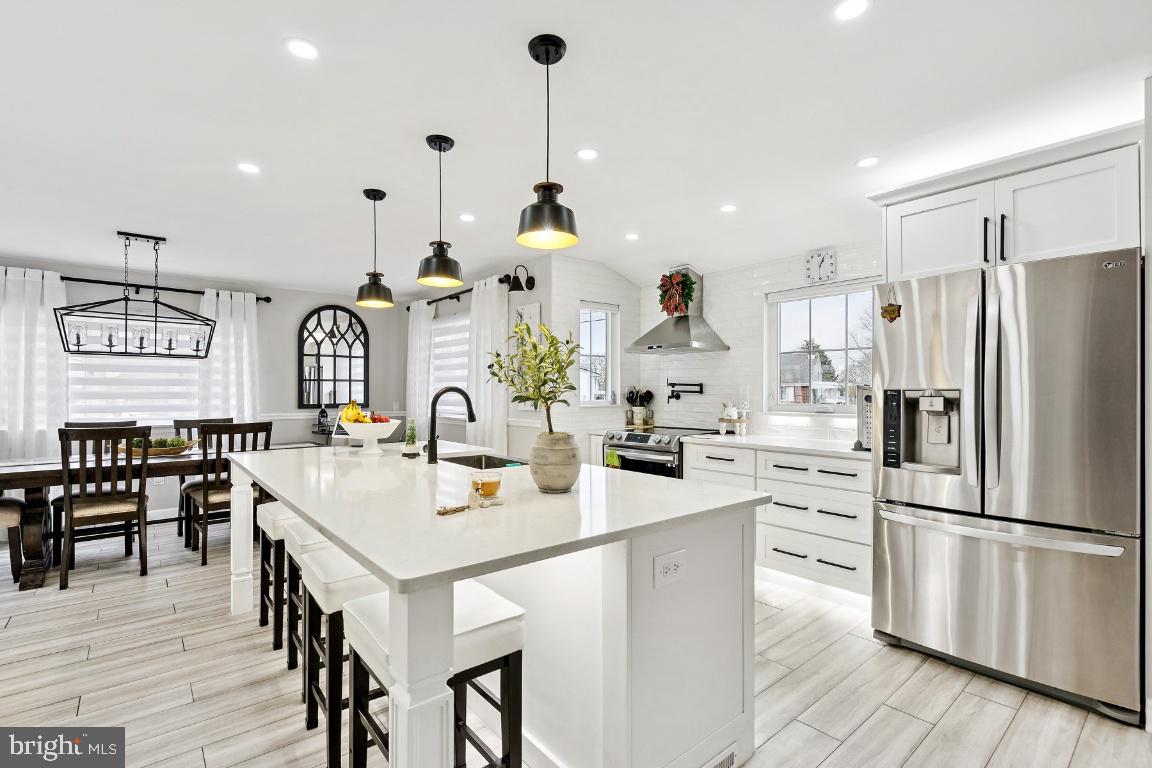 13 Belmont Road Bellmawr, NJ 08031 - Photo 3 of 32 a kitchen with stainless steel appliances kitchen island granite countertop a refrigerator a sink a stove and island with wooden floor