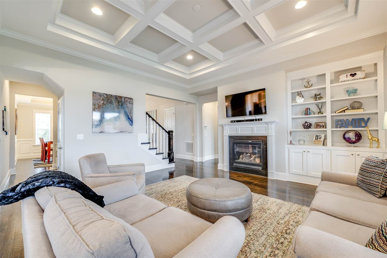 7504 Pinaster Place Raleigh, NC 27613 - Photo 4 of 30 Relax in this spacious family room fully equipped w/ a fireplace, site finish hardwoods, coffered ceiling, recessed can lights, built-in shelves and more! Family Room