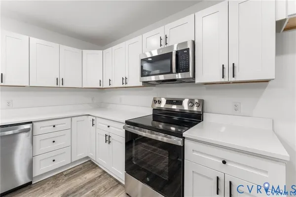 a kitchen with white cabinets and stainless steel appliances
