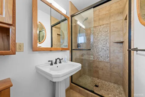 a bathroom with a sink shower and a mirror