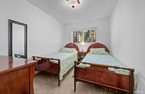 a bedroom with two beds and wooden floor