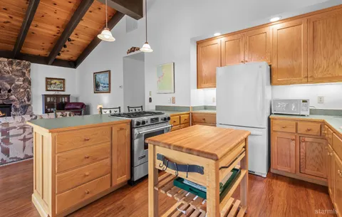 a kitchen with stainless steel appliances sink cabinets and wooden floor