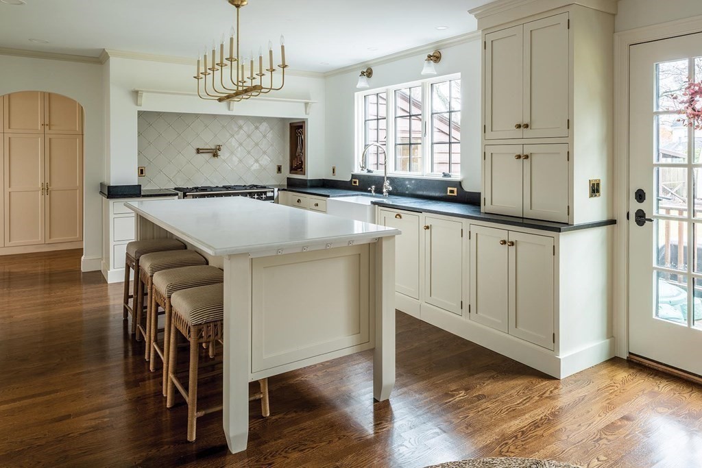 92 Gordon Road Newton, MA 02468 - Photo 4 of 16 a kitchen with kitchen island granite countertop wooden floors and white cabinets
