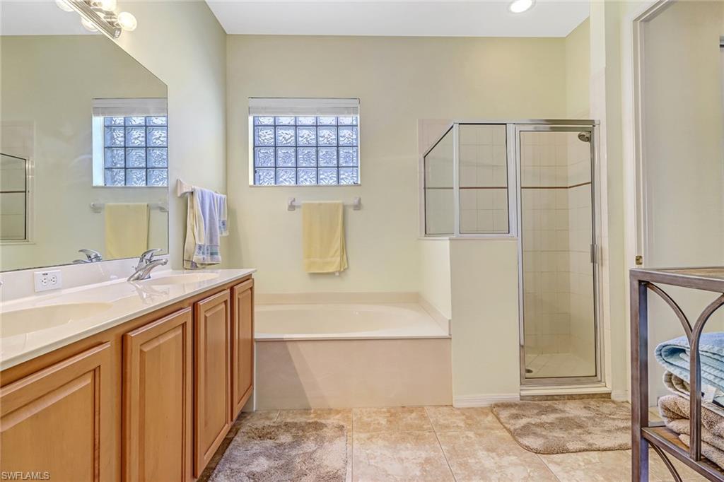 76 Glen Eagle Circle Naples, FL 34104 - Photo 12 of 23 a bathroom with a sink a mirror and a shower