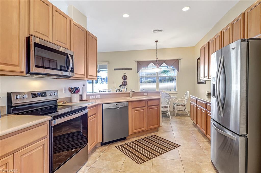 76 Glen Eagle Circle Naples, FL 34104 - Photo 4 of 23 a kitchen with stainless steel appliances a stove a sink and a refrigerator