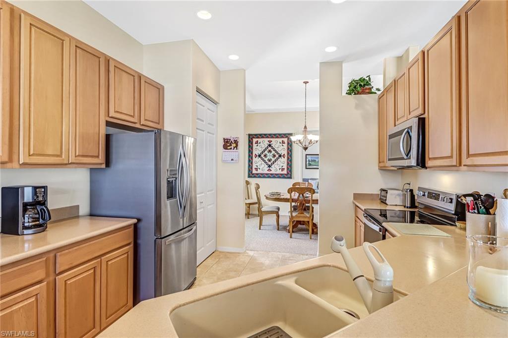 76 Glen Eagle Circle Naples, FL 34104 - Photo 7 of 23 a kitchen with stainless steel appliances granite countertop a refrigerator a sink a stove and white cabinets with wooden floor