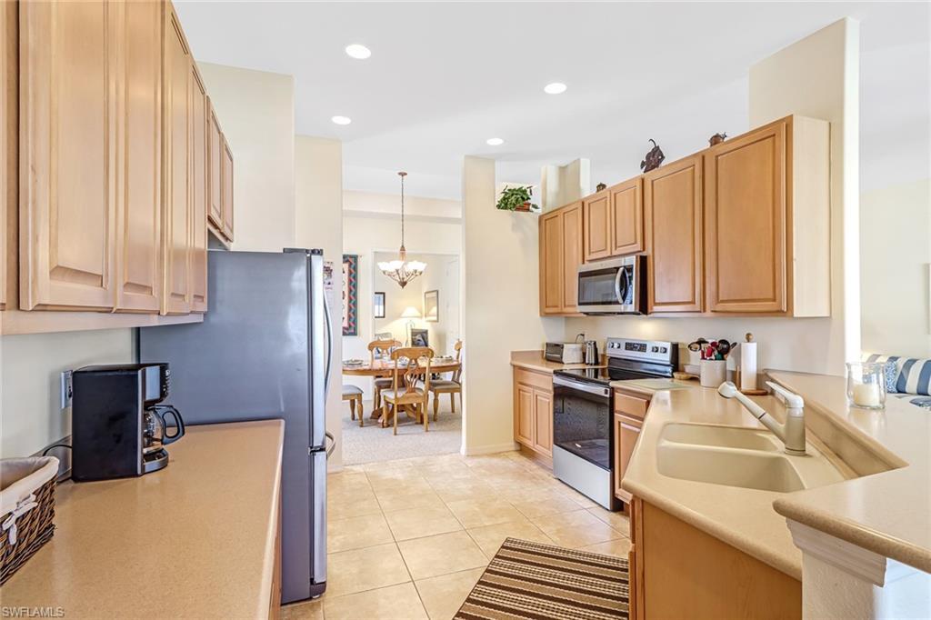 76 Glen Eagle Circle Naples, FL 34104 - Photo 8 of 23 a kitchen with stainless steel appliances granite countertop a refrigerator sink and cabinets