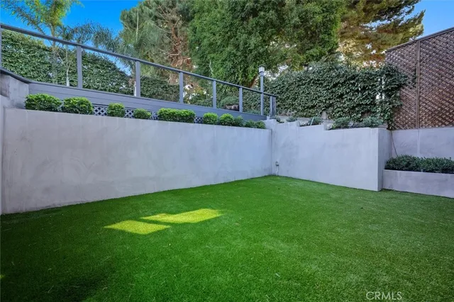an outdoor sitting area with furniture and garden