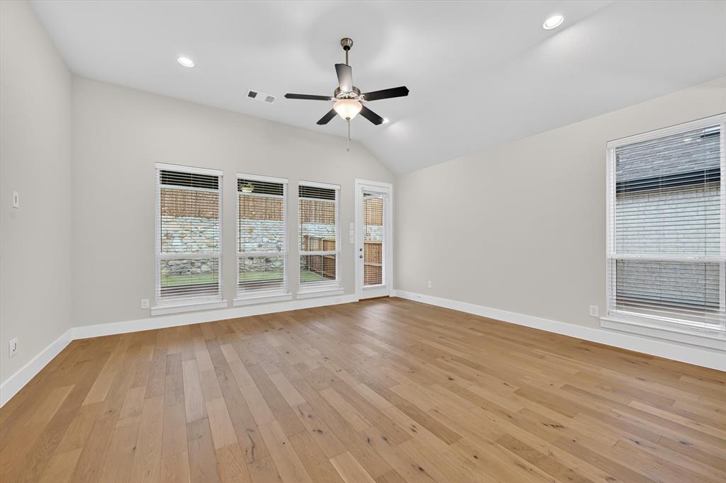4123 Windy Point Court Oak Point, TX 75068 - Photo 13 of 29 Spacious room featuring vaulted ceilings, recessed lighting, wood-finish flooring, and multiple windows with blinds