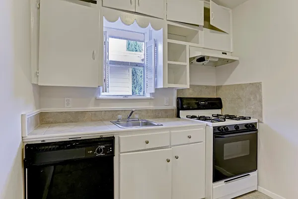 a kitchen with a stove sink and cabinets