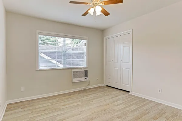 a view of an empty room with wooden floor and a window