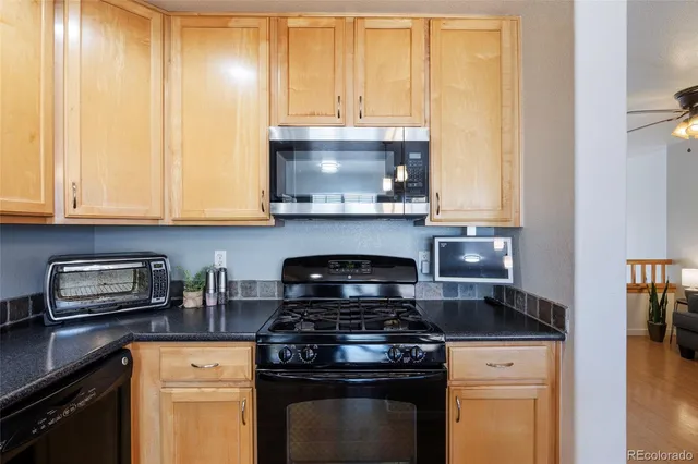 a kitchen with granite countertop a stove and a white cabinets