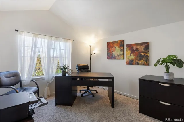 a view of a workspace with furniture and a window