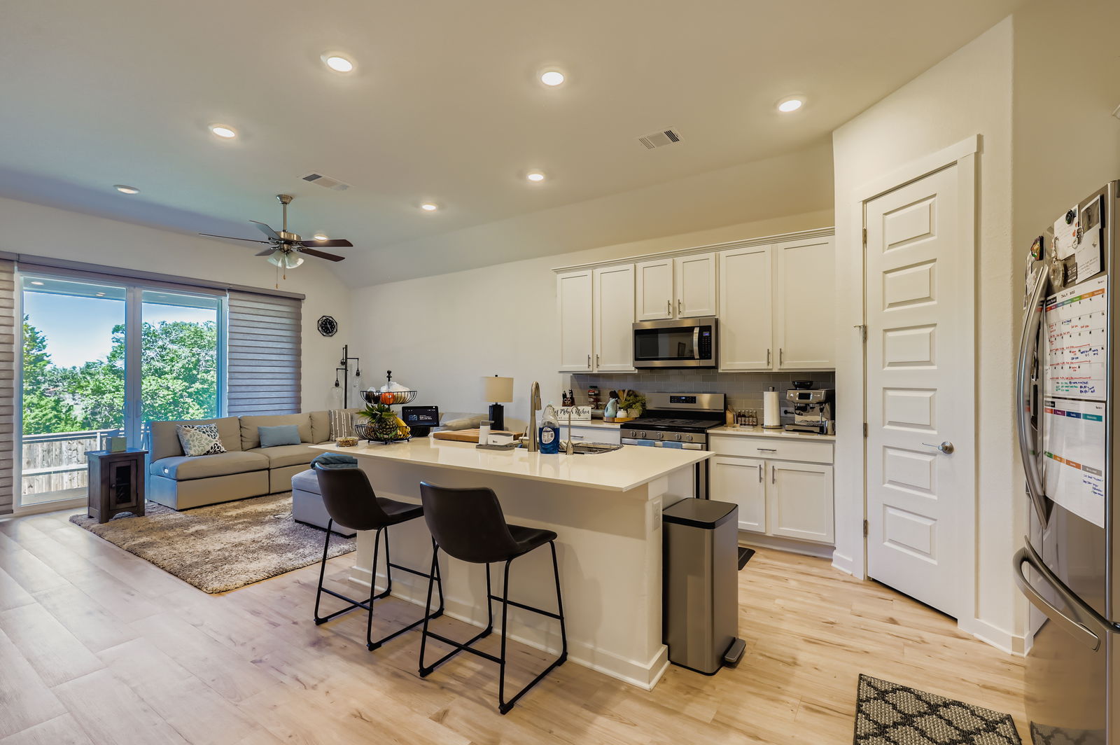 1909 Ruger Pass Leander, TX 78641 - Photo 31 of 31 Kitchen featuring appliances with stainless steel finishes, a breakfast bar area, white cabinetry, ceiling fan, and open floor plan