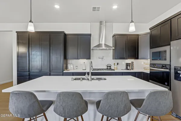 a kitchen with stainless steel appliances a sink a stove a refrigerator and cabinets