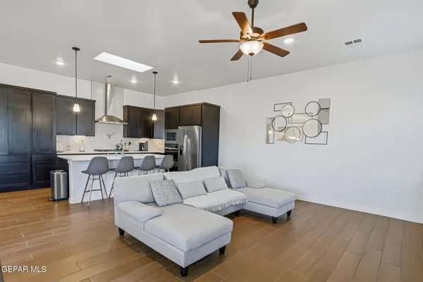 a living room with furniture kitchen view and a chandelier