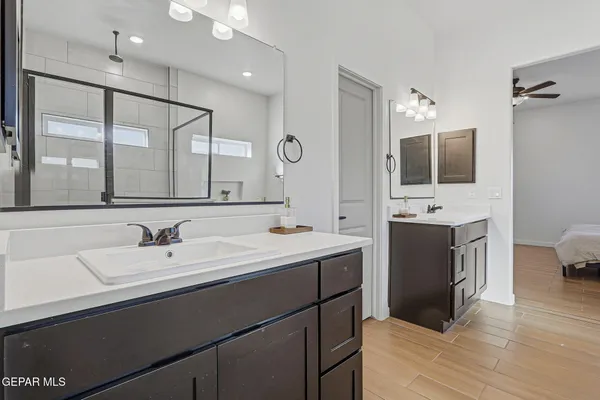 a bathroom with a double vanity sink a mirror and a shower