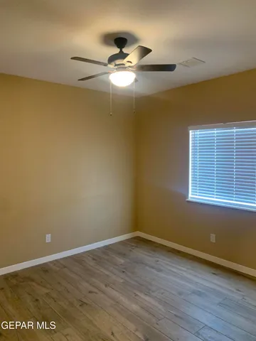 a view of a room with wooden floor and ceiling fan