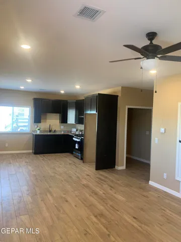 a large room with stainless steel appliances kitchen island granite countertop a refrigerator and a sink