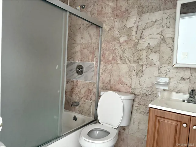 a bathroom with a granite countertop toilet a sink and a shower
