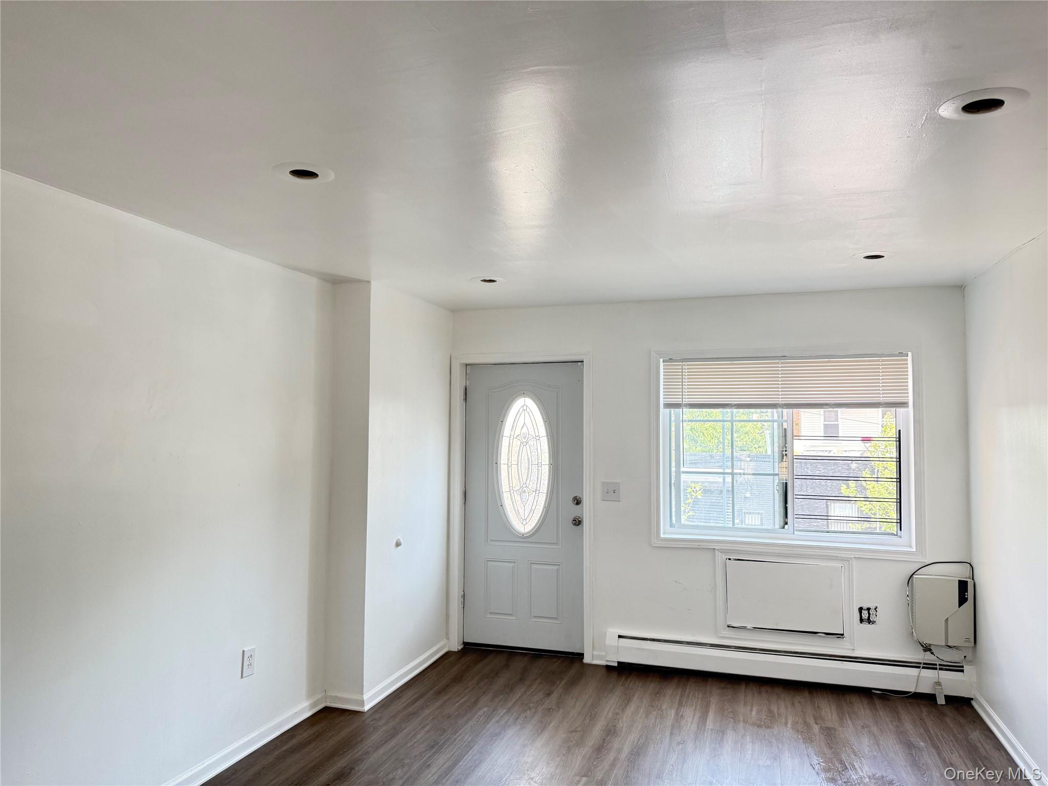 97-56 101st Street Queens, NY 11416 - Photo 3 of 17 an empty room with wooden floor and window