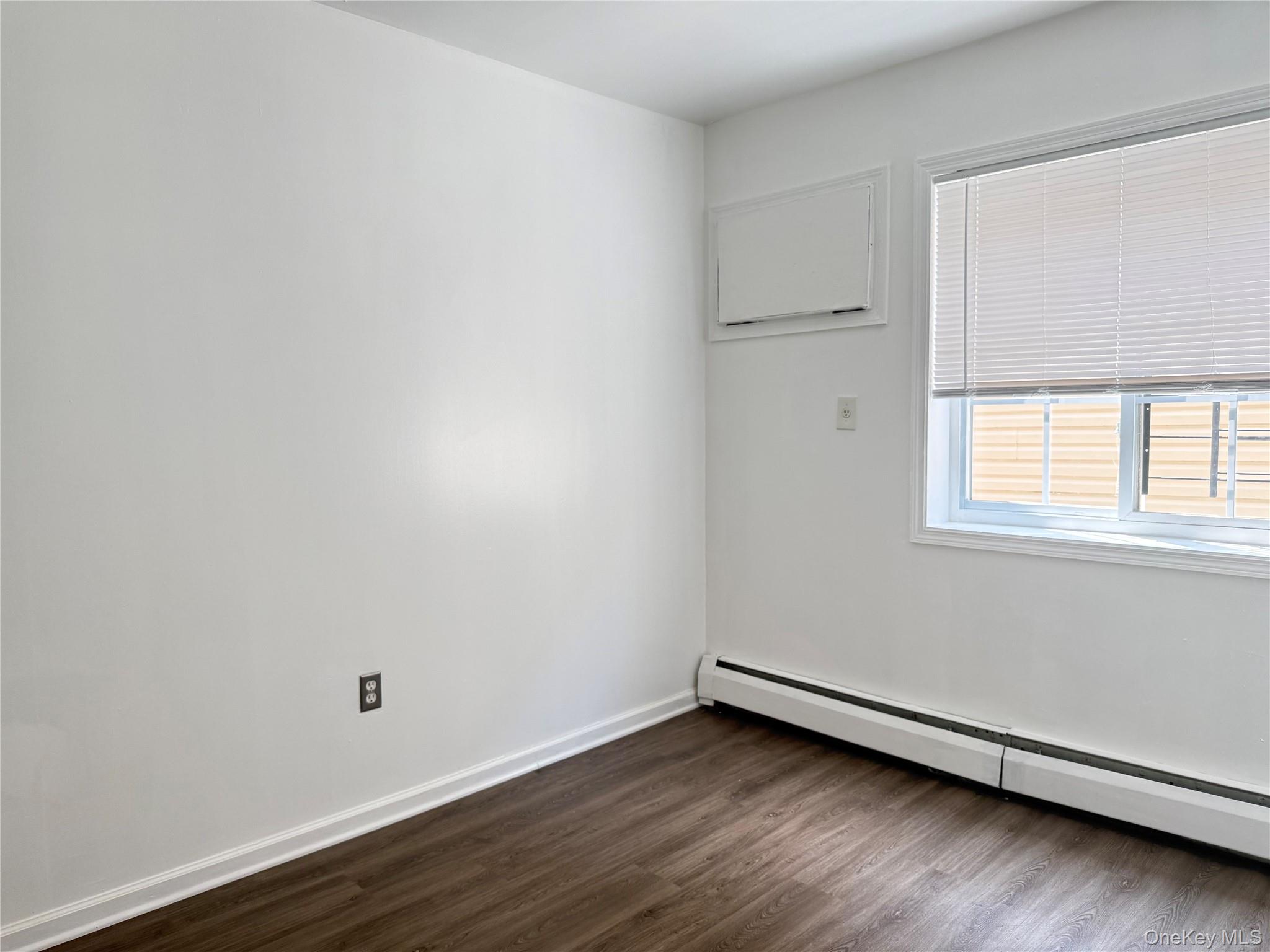 97-56 101st Street Queens, NY 11416 - Photo 5 of 17 an empty room with wooden floor and windows
