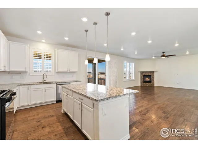 a open kitchen with granite countertop a sink and white cabinets