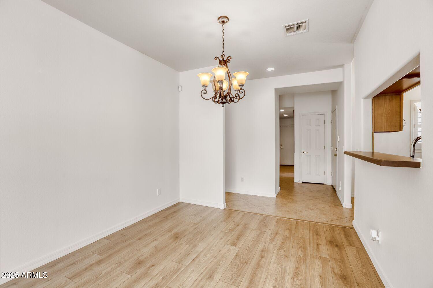 7101 West Beardsley Road, Unit 1403 Glendale, AZ 85308 - Photo 10 of 40 a view of a kitchen with wooden floor and a chandelier