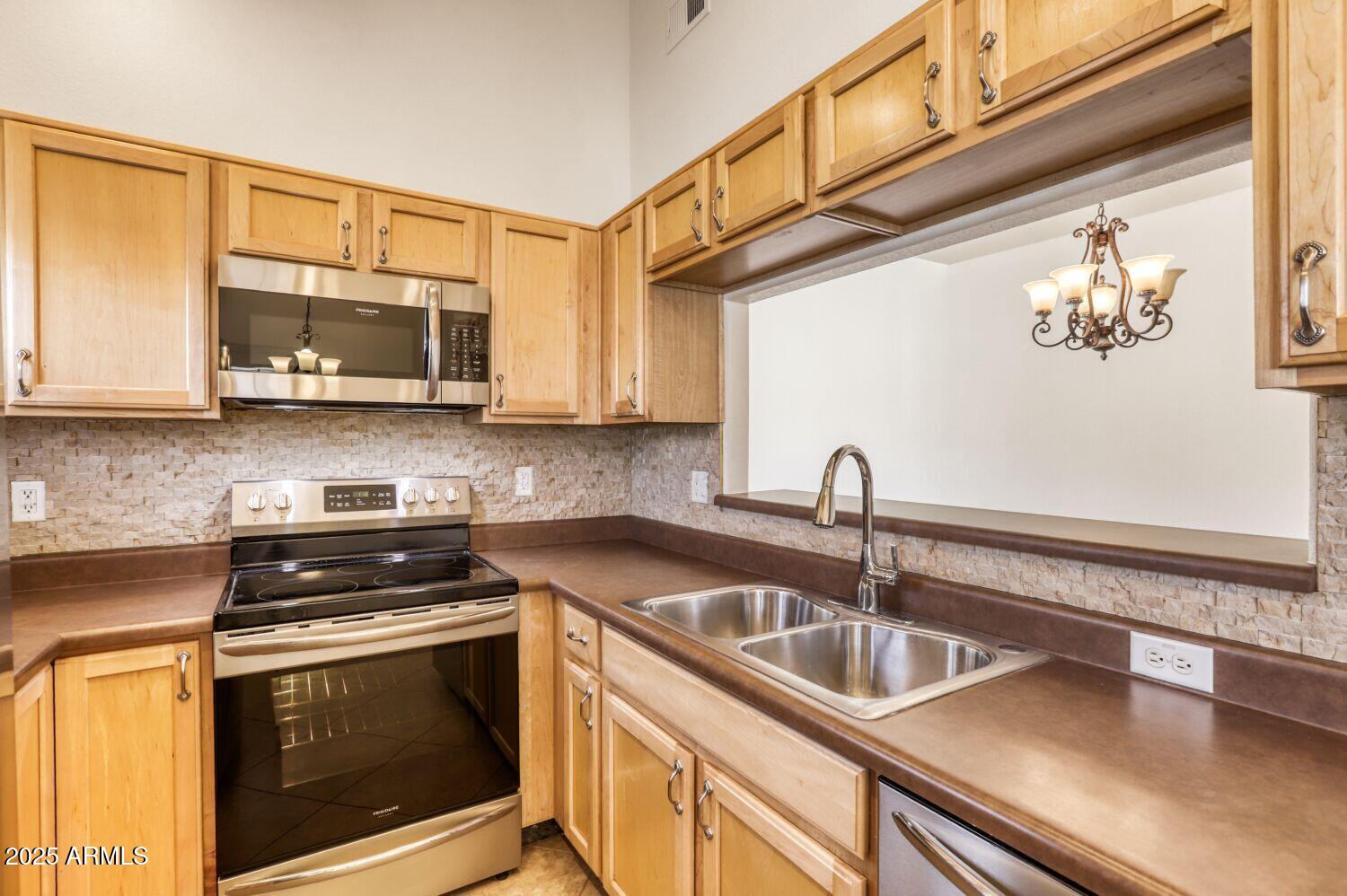 7101 West Beardsley Road, Unit 1403 Glendale, AZ 85308 - Photo 14 of 40 a kitchen with stainless steel appliances granite countertop a sink a stove and cabinets
