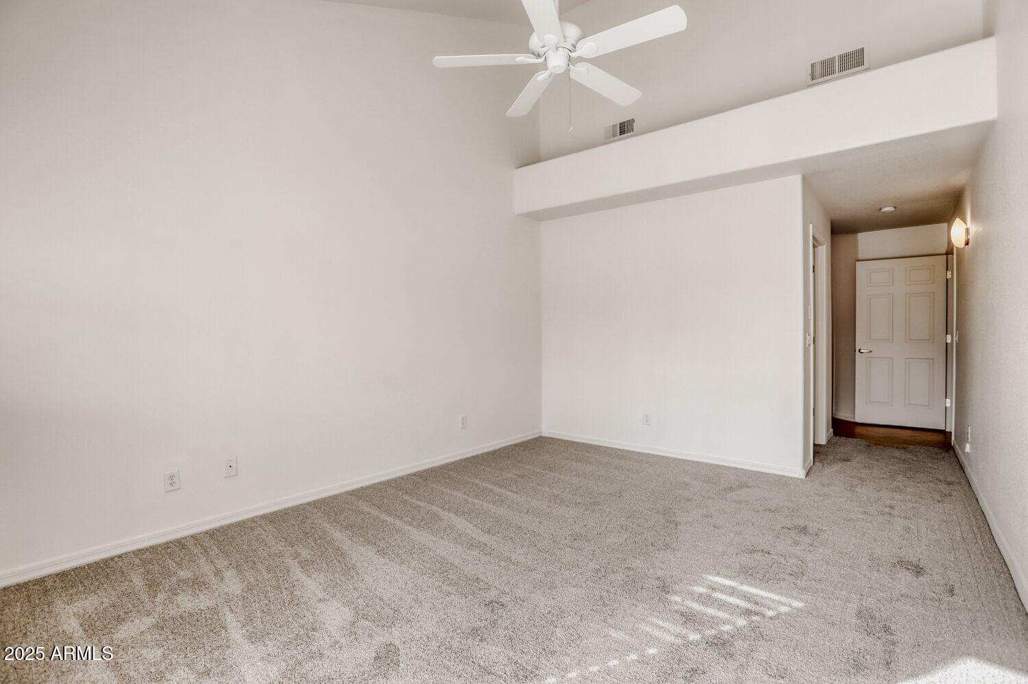 7101 West Beardsley Road, Unit 1403 Glendale, AZ 85308 - Photo 19 of 40 an empty room with a ceiling fan and carpet