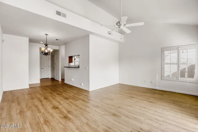 a view of a room with wooden floor and ceiling fan