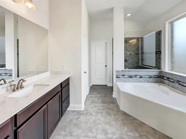 a spacious bathroom with a bathtub sink and mirror