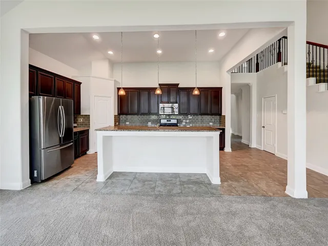 a view of kitchen with refrigerator stove and microwave