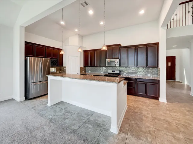 a kitchen with stainless steel appliances granite countertop a refrigerator stove and oven