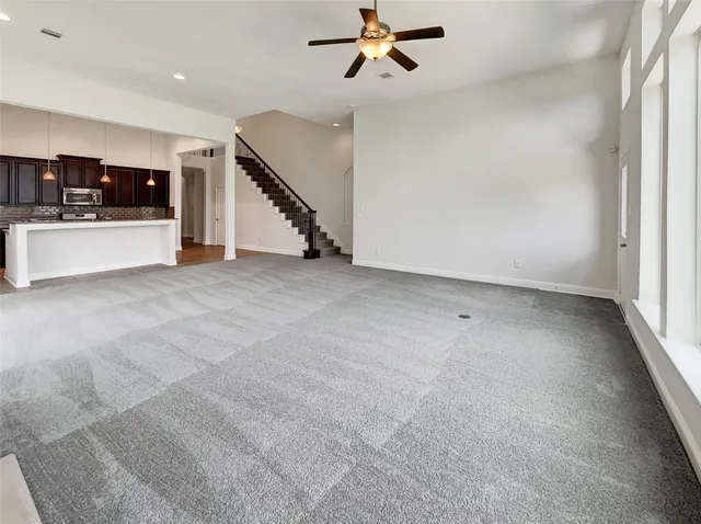 an empty room with windows and stairs