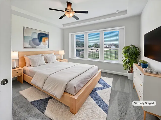 a spacious bedroom with a large bed and a flat screen tv