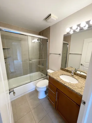 a bathroom with a granite countertop sink a toilet and shower