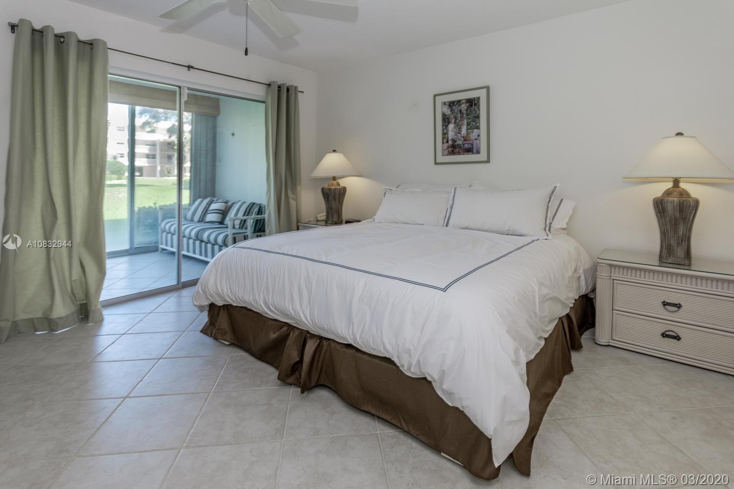 80 Celestial Way, Unit 108 Juno Beach, FL 33408 - Photo 13 of 34 Large master bedroom with king sized bed opens to the glass porch and views of the lawn
