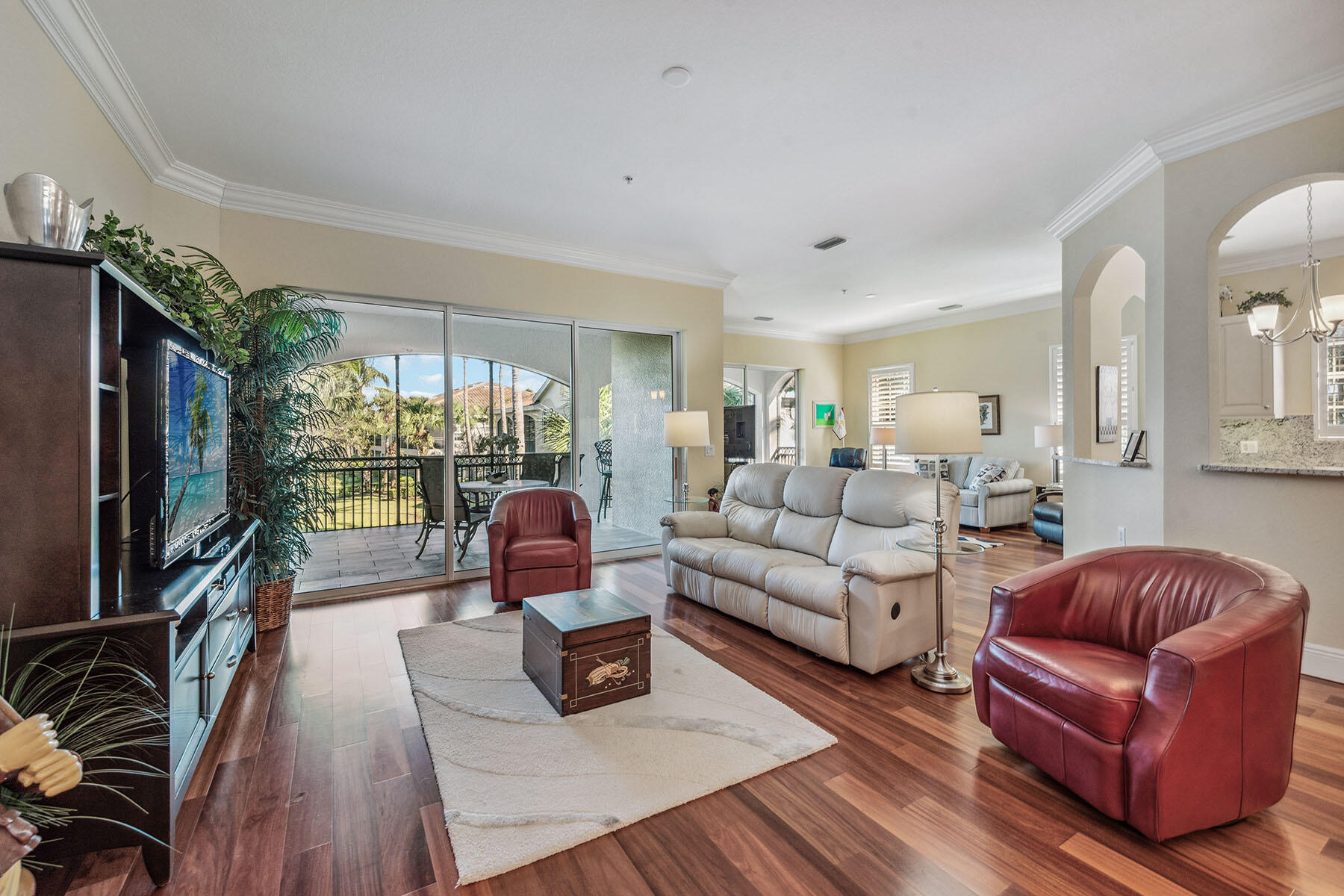 3189 Aviamar Circle, Unit 202 Naples, FL 34114 - Photo 3 of 50 a living room with furniture a flat screen tv and floor to ceiling windows