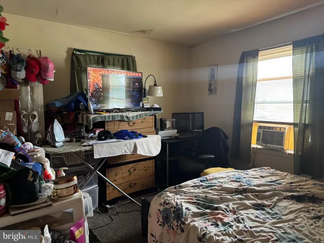 a bedroom with a bed desk and a window